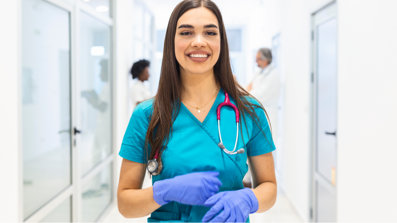 Clinical Medical Assistant Photo Woman hospital worker looking at camera and smiling, hospital background