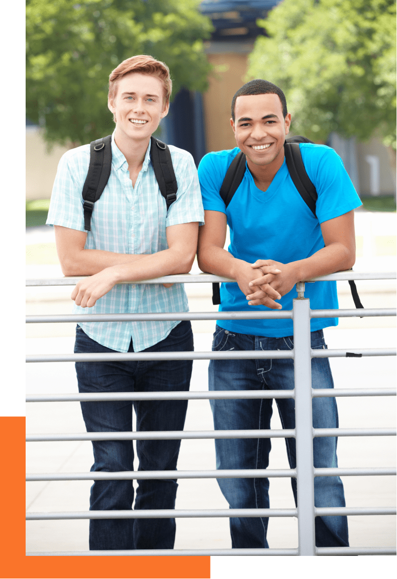 Two young male students smiling outside with backpacks on